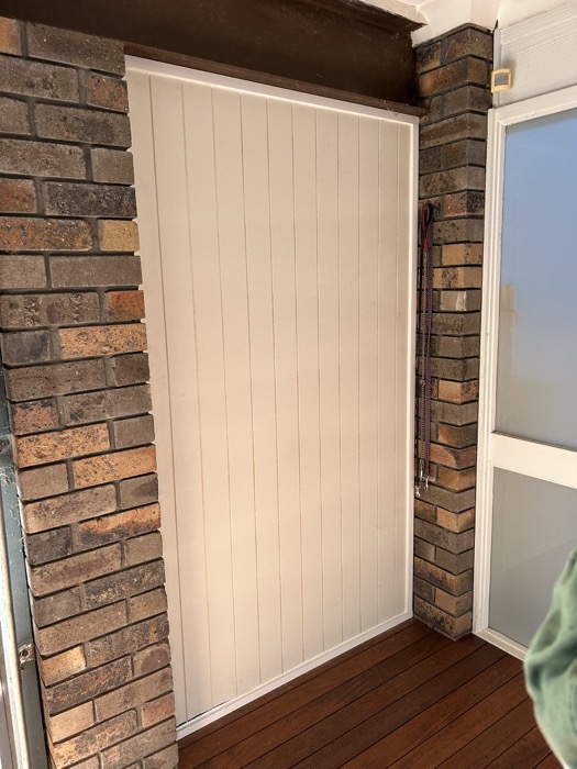 Custom privacy panel fitted between brick piers on a deck — Northern Beaches
